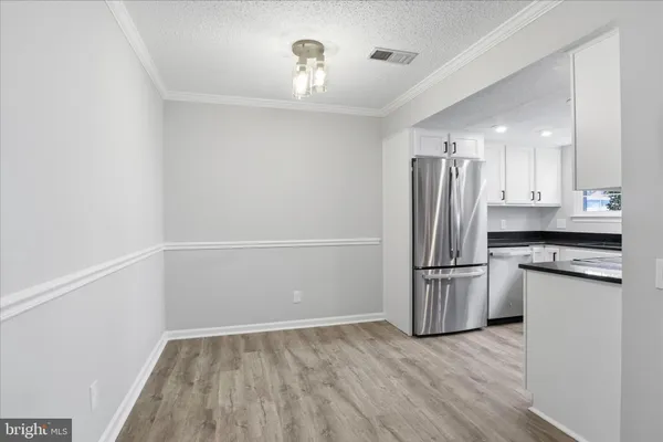 a view of a kitchen with a sink refrigerator and wooden floor