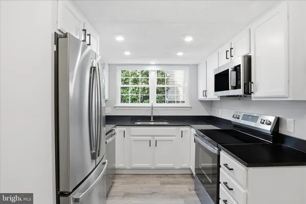 a kitchen with a sink stove and microwave