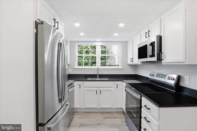 a kitchen with a sink stove and microwave