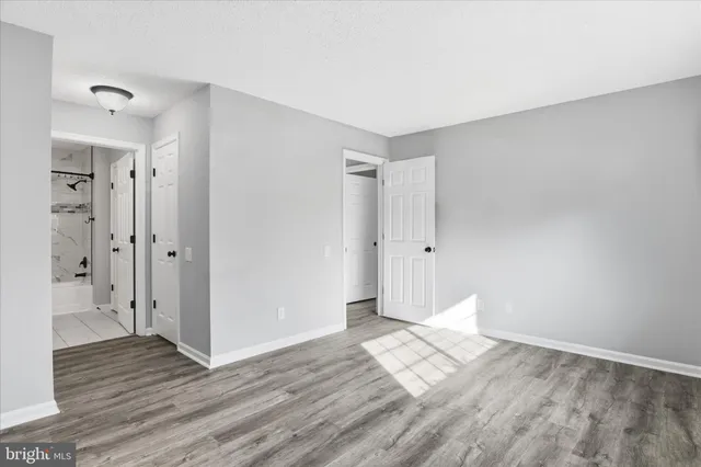 a view of empty room with wooden floor