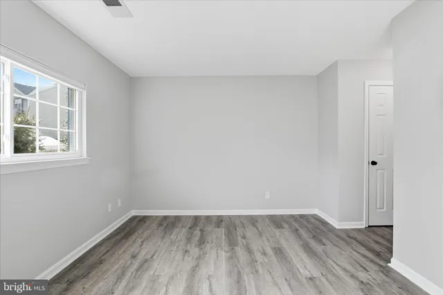 a view of a room that has wooden floor and windows in it