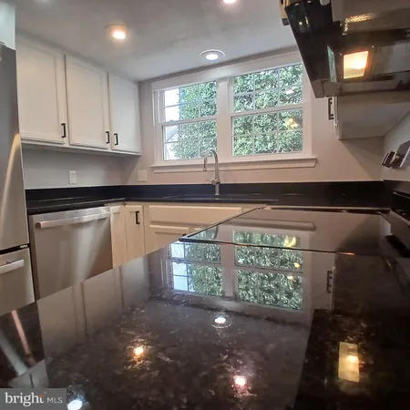 a kitchen with granite countertop a stove a sink and a window