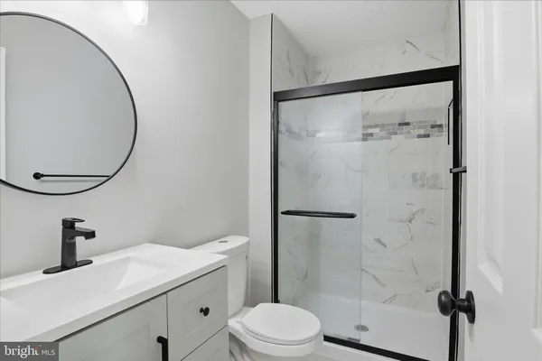 a bathroom with a sink vanity mirror and toilet