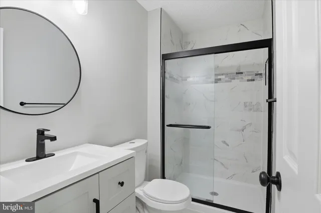 a bathroom with a sink vanity mirror and toilet