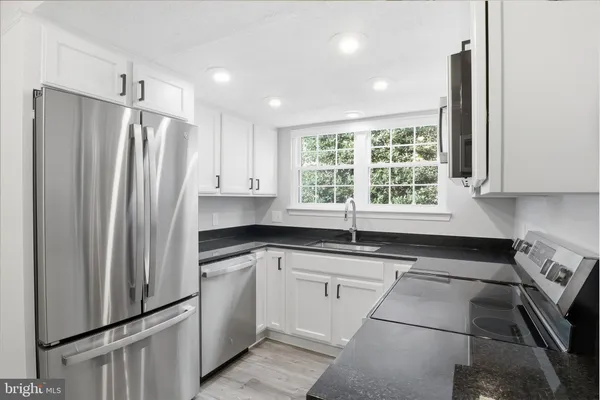 a kitchen with granite countertop a refrigerator sink and window