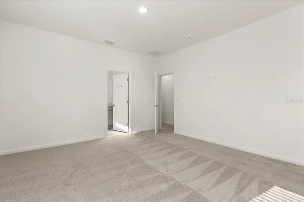 a view of an empty room with a cabinet and mirrors