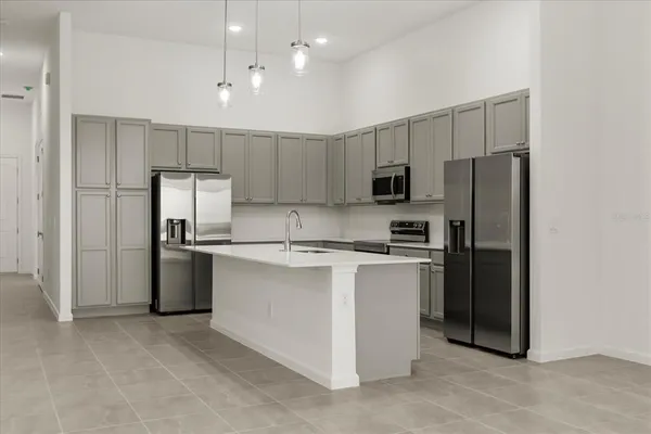 a large kitchen with granite countertop a stove top oven a sink a counter space and cabinets