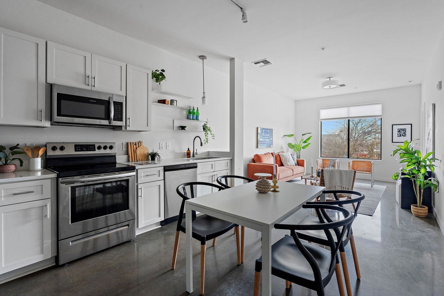 a kitchen with stainless steel appliances a white table and chairs in it