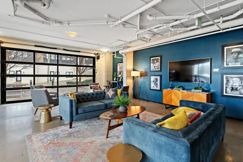 a living room with furniture flat screen tv and a large window