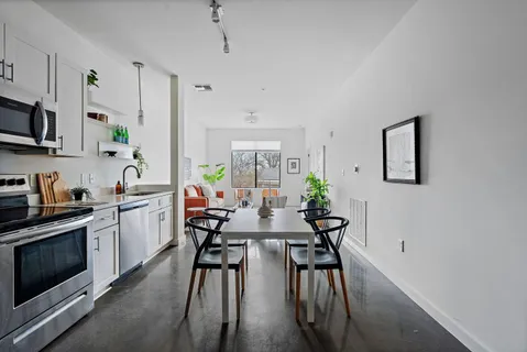 a view of a dining room with furniture a rug and wooden floor
