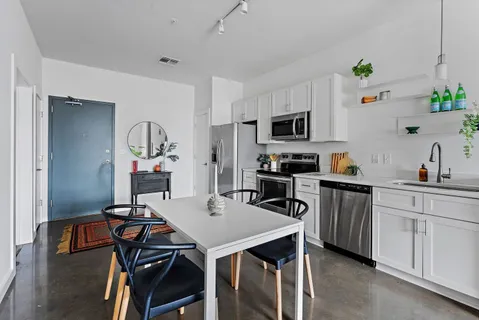 a kitchen with a table chairs refrigerator and microwave