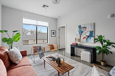 a living room with furniture and a potted plant