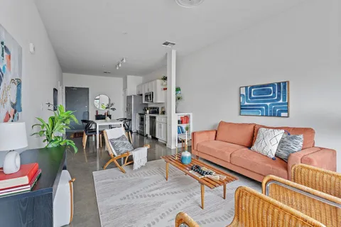 a living room with furniture kitchen view and a rug