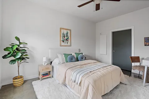 a bedroom with a bed and a potted plant