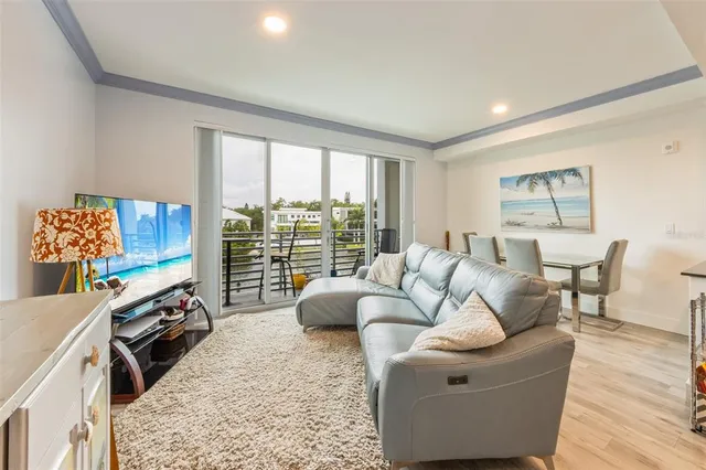 a living room with furniture floor to ceiling window and a flat screen tv