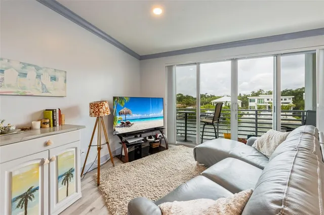 a living room with furniture a flat screen tv and a large window