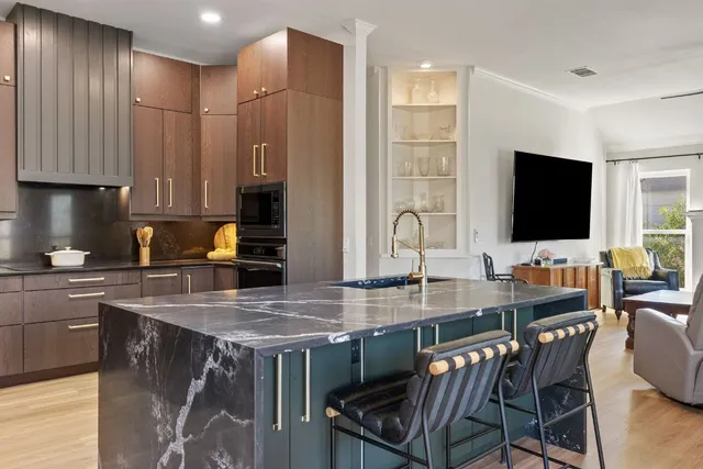 a kitchen with stainless steel appliances granite countertop a table chairs and a refrigerator
