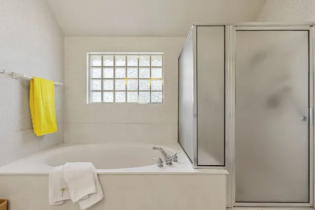a spacious bathroom with a double vanity sink a mirror and a bathtub