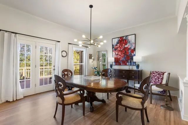 a dining room with furniture a chandelier and wooden floor
