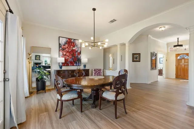 a dining room with furniture a chandelier and wooden floor