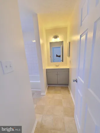 a bathroom with a tub sink and mirror