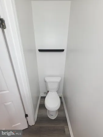 a white toilet sitting next to a white wall