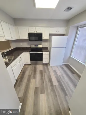 a kitchen with sink a microwave and refrigerator