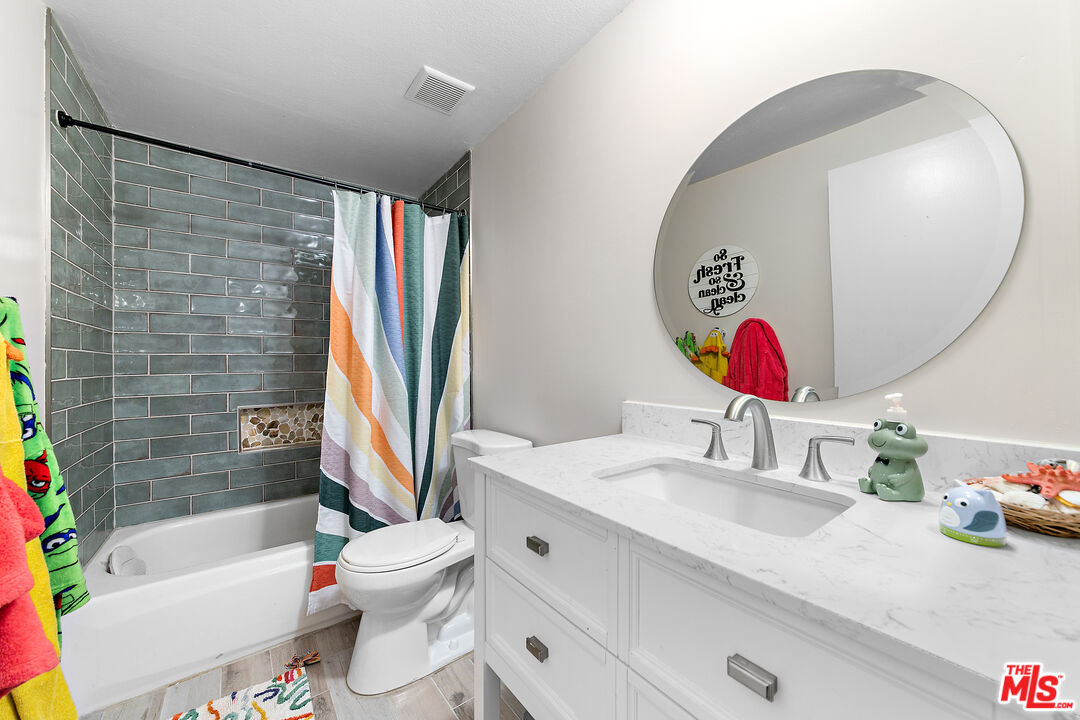 5139 Balboa Boulevard, Unit 9 Encino, CA 91316 - Photo 12 of 30 a bathroom with a granite countertop sink mirror vanity and toilet