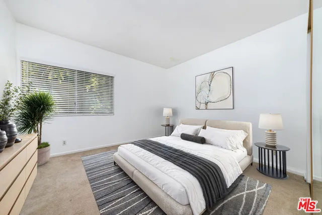 a bedroom with bed and a potted plant
