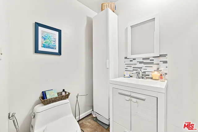 a bathroom with a toilet sink vanity and mirror
