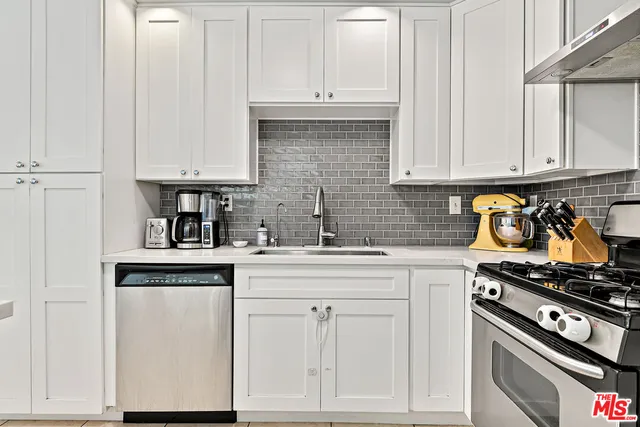 a kitchen with white cabinets and appliances