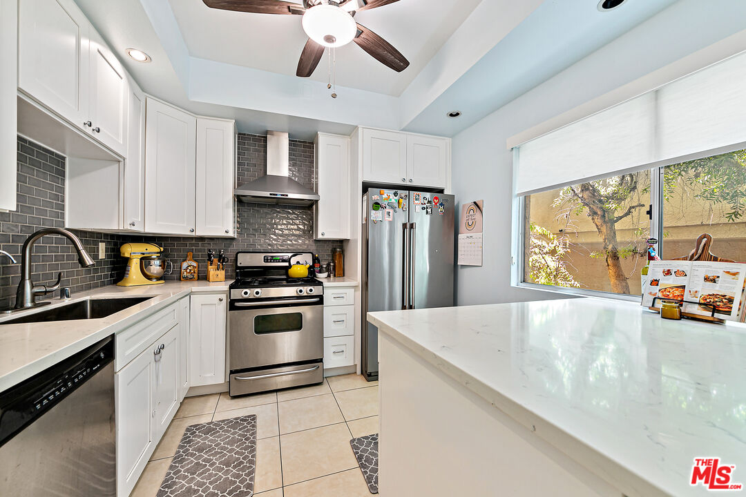 5139 Balboa Boulevard, Unit 9 Encino, CA 91316 - Photo 23 of 30 a kitchen with stainless steel appliances granite countertop a sink a stove and refrigerator