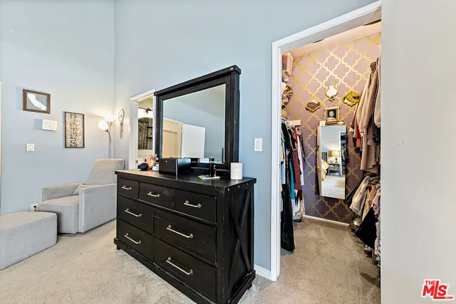 a room with a bed and a mirror on the dresser