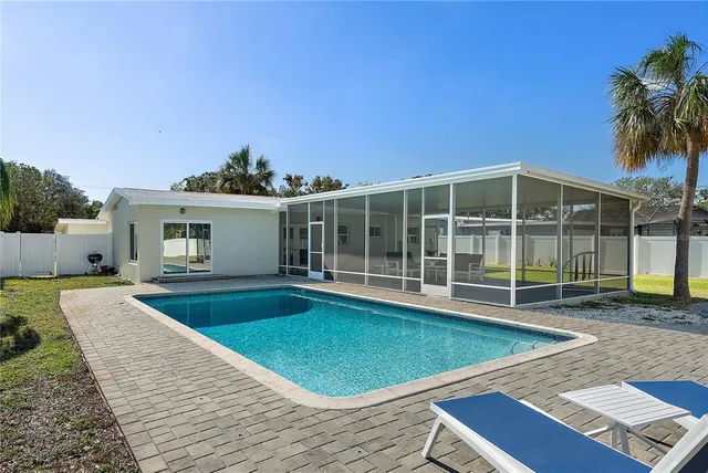 a view of a house with swimming pool and sitting area