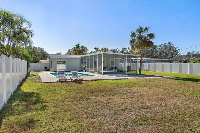a swimming pool with outdoor seating and yard