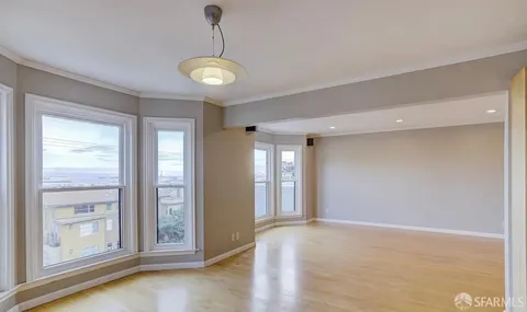 a view of a room with wooden floor and window