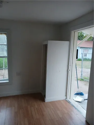 an empty room with wooden floor and a window
