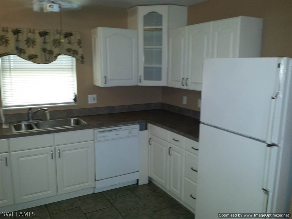 7263 Barragan Road, Unit 3 Fort Myers, FL 33967 - Photo 2 of 11 a kitchen with white cabinets and white appliances