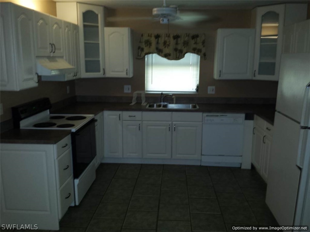 7263 Barragan Road, Unit 3 Fort Myers, FL 33967 - Photo 3 of 11 a kitchen with granite countertop white cabinets and a stove