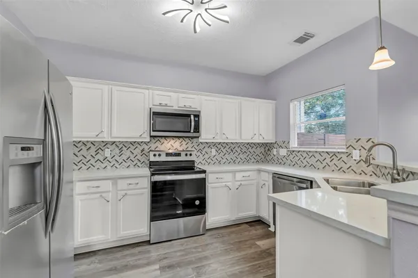 a kitchen with a sink stove and microwave
