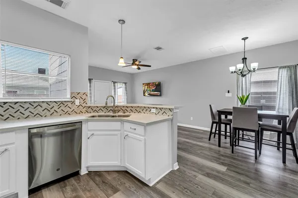 a kitchen with a sink stove and wooden floor
