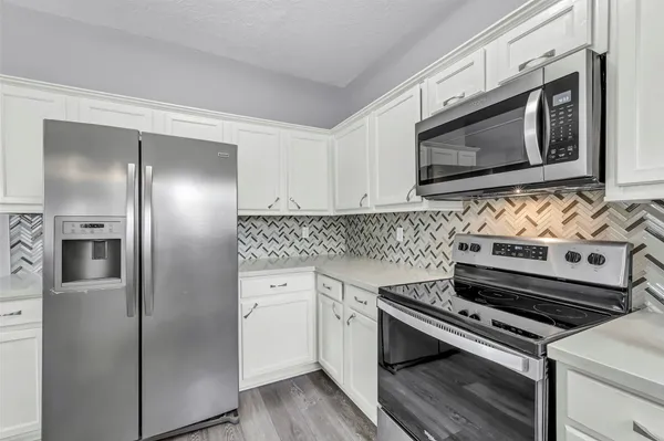a kitchen with cabinets and steel stainless steel appliances