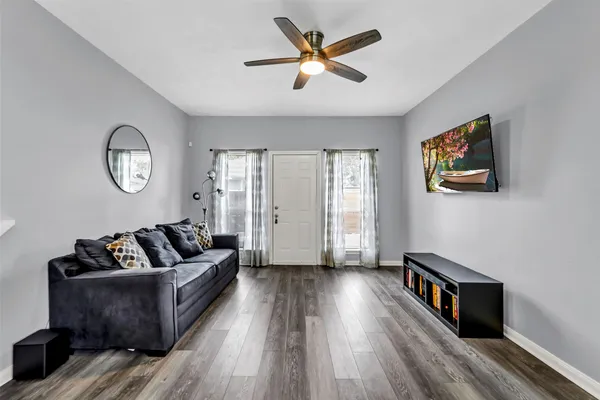 a living room with furniture wooden floor and a large window