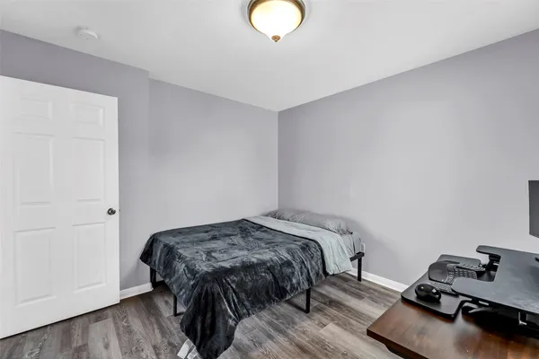 a bedroom with a bed and wooden floor