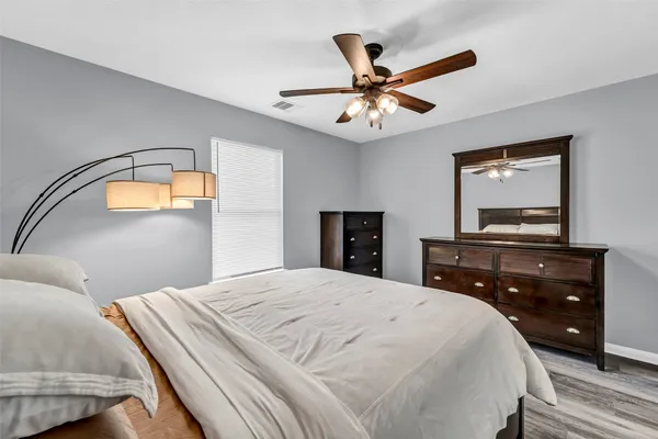 a bedroom with a bed and a mirror on the dresser