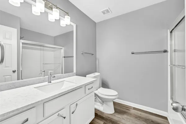 a bathroom with a sink a toilet and a mirror