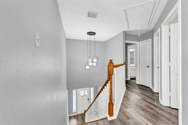 a view of a hallway with wooden floor and staircase