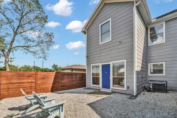 a backyard of a house with barbeque oven table and chairs
