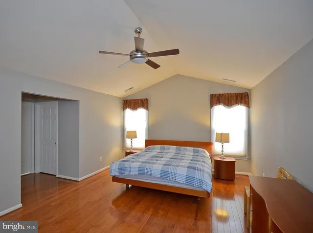 a view of a room with a ceiling fan and hardwood floor