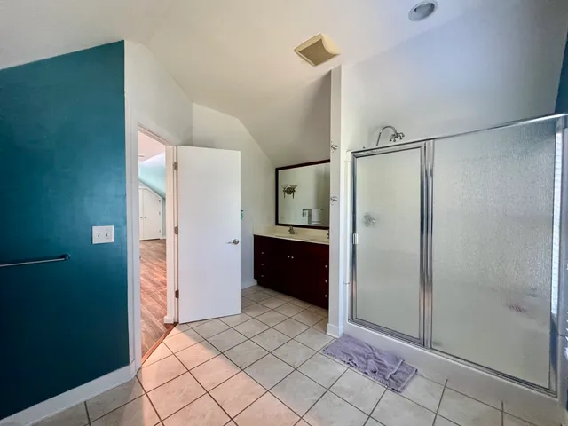 a bathroom with a mirror a shower and a sink